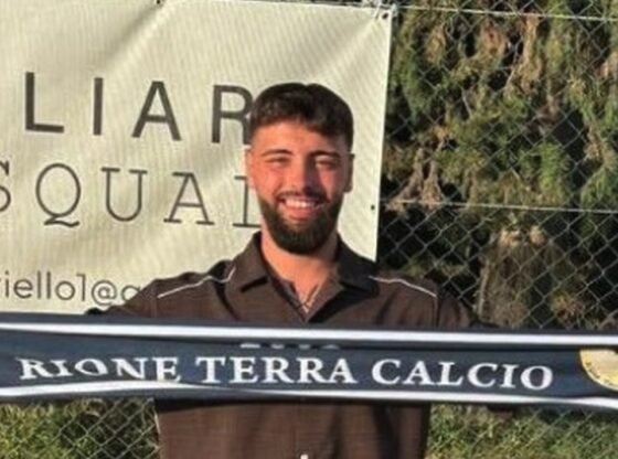 Umberto Catanzaro segurando um lenço Rione Terra Calcio.