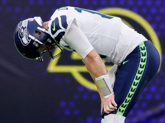 O quarterback do Seattle Seahawks, Sam Darnold, coloca as mãos nos joelhos depois de lançar sua terceira interceptação do jogo durante o terceiro quarto, domingo, 16 de novembro de 2025, em Inglewood, CA. 231552